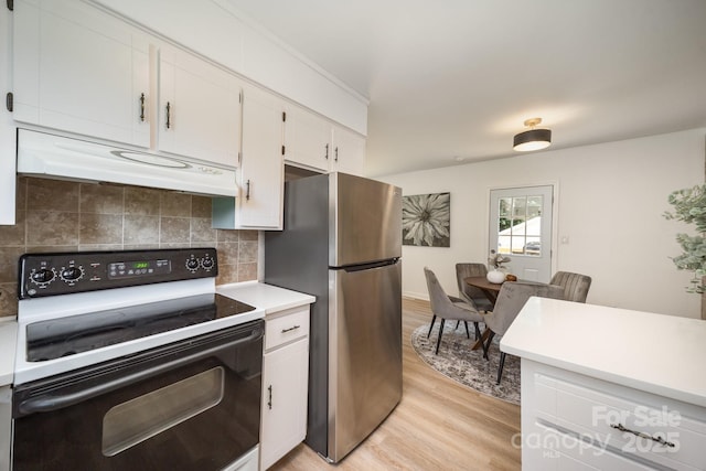 3427 Wonderland Dr, Matthews, NC 28104 - kitchen with range with electric stovetop, freestanding refrigerator, under cabinet range hood, light wood finished floors, and light countertops