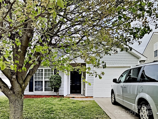 1703 Southwind Dr, Charlotte, NC 28216 - view of property hidden behind natural elements featuring an attached garage, a front yard, and concrete driveway