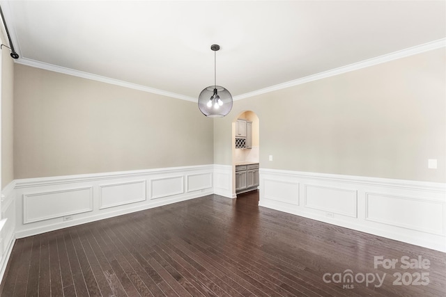 2525 Surveyor General Dr, Waxhaw, NC 28173 - unfurnished dining area featuring ornamental molding, a wainscoted wall, arched walkways, and dark wood-type flooring