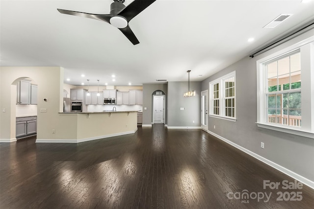 2525 Surveyor General Dr, Waxhaw, NC 28173 - unfurnished living room featuring recessed lighting, ceiling fan, dark wood finished floors, and arched walkways