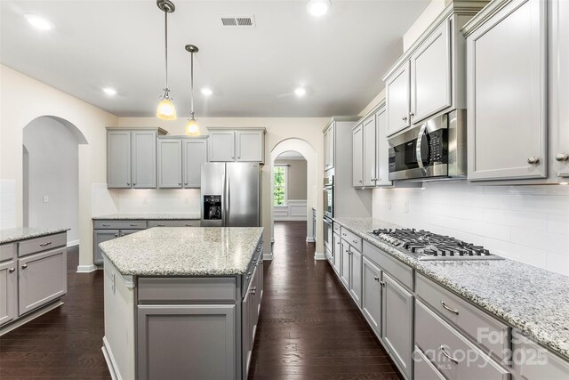 2525 Surveyor General Dr, Waxhaw, NC 28173 - kitchen with arched walkways, gray cabinets, appliances with stainless steel finishes, tasteful backsplash, and recessed lighting