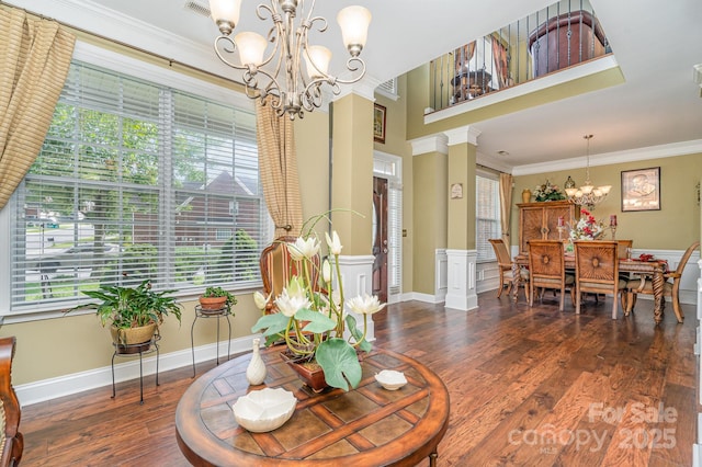 10812 Clark St, Davidson, NC 28036 - living area featuring a chandelier, healthy amount of natural light, wood finished floors, crown molding, and decorative columns