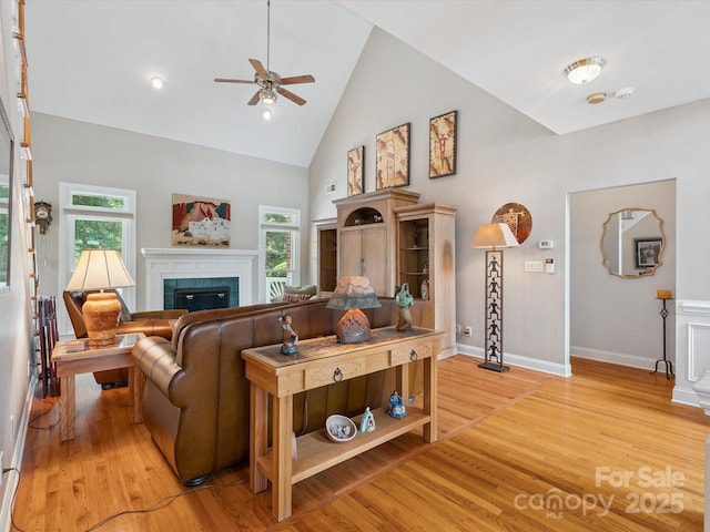 13101 Kensworth Ct, Charlotte, NC 28277 - living room featuring ceiling fan, light wood-style flooring, a tile fireplace, high vaulted ceiling, and plenty of natural light