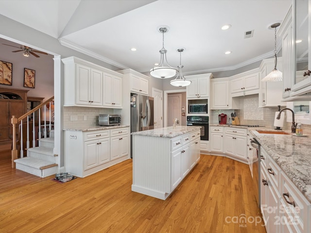 13101 Kensworth Ct, Charlotte, NC 28277 - kitchen featuring appliances with stainless steel finishes, a ceiling fan, white cabinets, crown molding, and backsplash