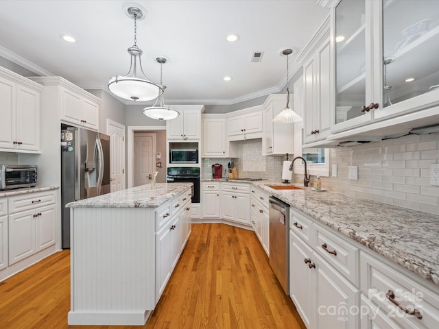 13101 Kensworth Ct, Charlotte, NC 28277 - kitchen featuring black appliances, white cabinets, a center island, glass insert cabinets, and crown molding