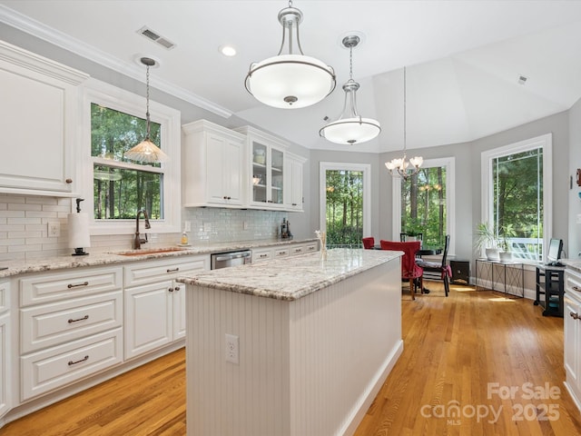 13101 Kensworth Ct, Charlotte, NC 28277 - kitchen with light wood-style floors, white cabinets, a kitchen island, decorative backsplash, and ornamental molding