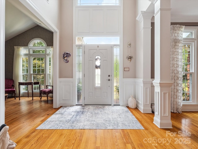 13101 Kensworth Ct, Charlotte, NC 28277 - foyer entrance featuring healthy amount of natural light, a high ceiling, a decorative wall, light wood-type flooring, and decorative columns