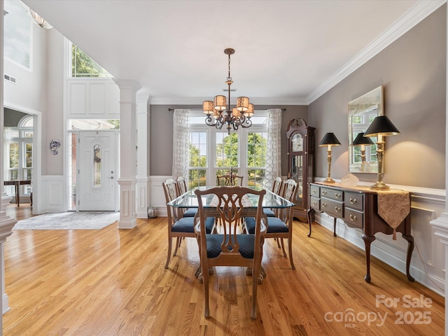 13101 Kensworth Ct, Charlotte, NC 28277 - dining room with a chandelier, plenty of natural light, light wood-style flooring, a decorative wall, and ornamental molding