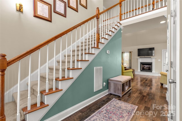 4114 Flint Dr, Lancaster, SC 29720 - staircase with wood finished floors, a high ceiling, and a fireplace with raised hearth