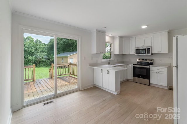 4146 Old State Rd, Newton, NC 28658 - kitchen with appliances with stainless steel finishes, light countertops, crown molding, white cabinets, and light wood finished floors