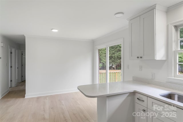 4146 Old State Rd, Newton, NC 28658 - kitchen featuring light countertops, white cabinetry, crown molding, light wood-style floors, and a peninsula