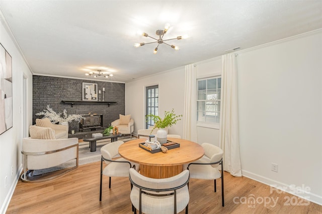 8025 Cliffside Dr, Charlotte, NC 28270 - dining space with a chandelier, crown molding, light wood-style floors, and a wood stove