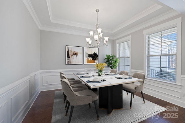 704 Kenway Loop, Mooresville, NC 28117 - dining space featuring a chandelier, dark wood-style flooring, a raised ceiling, a wainscoted wall, and crown molding