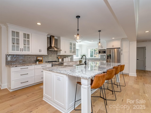 202 Walden Ln, Weddington, NC 28104 - kitchen with wall chimney range hood, stainless steel appliances, white cabinetry, decorative backsplash, and light wood finished floors