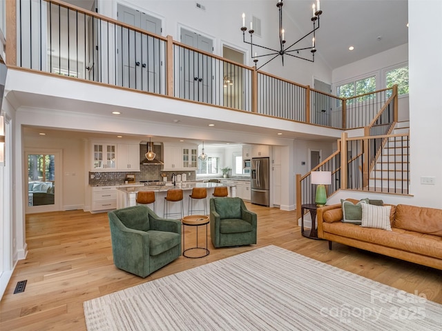 202 Walden Ln, Weddington, NC 28104 - living area featuring a high ceiling, a chandelier, stairway, light wood finished floors, and plenty of natural light