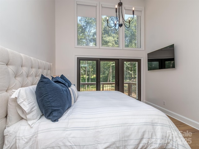 202 Walden Ln, Weddington, NC 28104 - bedroom with access to exterior, wood finished floors, a chandelier, and a high ceiling