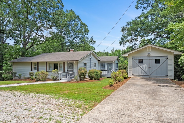 211 Woodland Rd, Tryon, NC 28782 - single story home featuring covered porch, an outbuilding, a front yard, driveway, and a garage