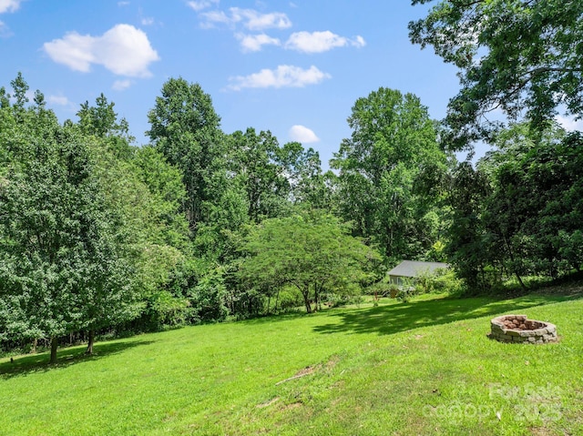 211 Woodland Rd, Tryon, NC 28782 - view of grassy yard with an outdoor fire pit and a forest view