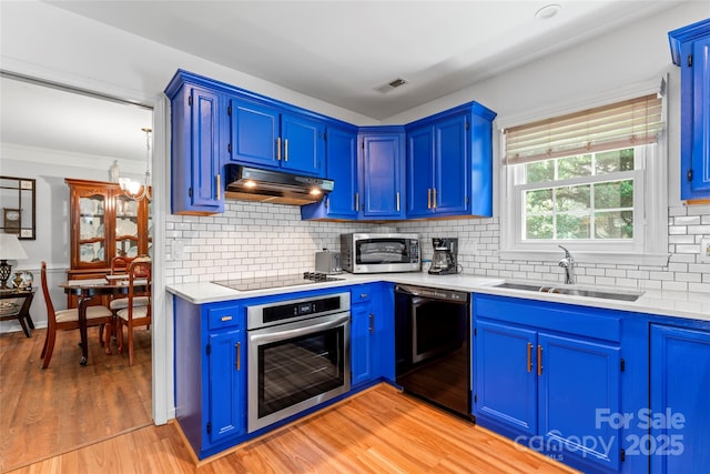 1109 Sunnyview Cir, Matthews, NC 28105 - kitchen with black appliances, under cabinet range hood, light countertops, blue cabinets, and decorative backsplash