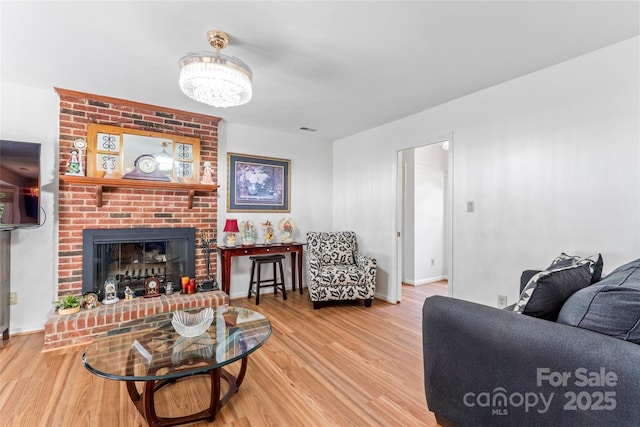 1109 Sunnyview Cir, Matthews, NC 28105 - living area with wood finished floors, a brick fireplace, and a chandelier