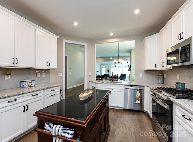 7337 Overjoyed Xing, Charlotte, NC 28215 - kitchen featuring appliances with stainless steel finishes, backsplash, white cabinetry, recessed lighting, and a chandelier