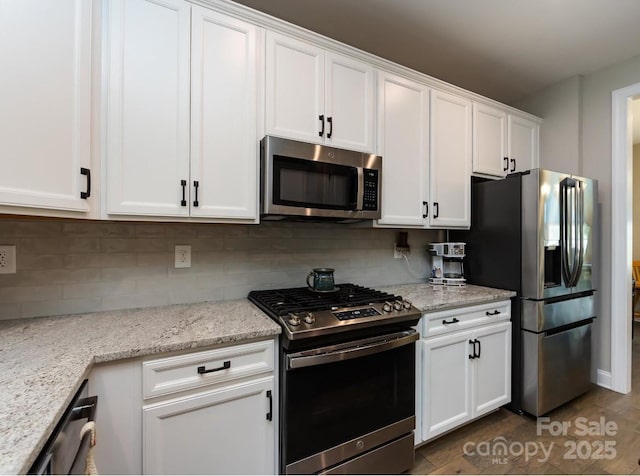 7337 Overjoyed Xing, Charlotte, NC 28215 - kitchen with appliances with stainless steel finishes, white cabinetry, decorative backsplash, and light stone countertops