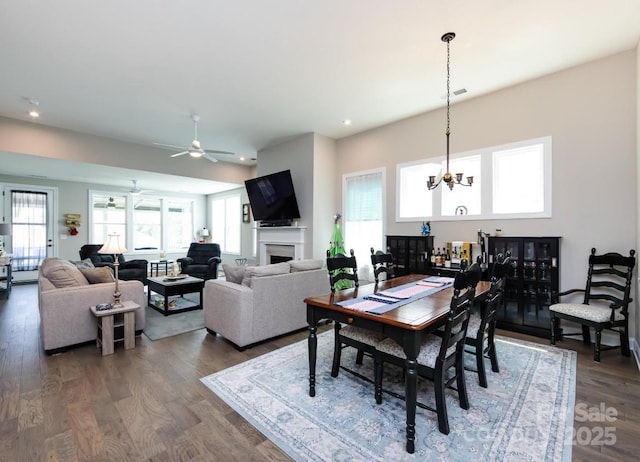 7337 Overjoyed Xing, Charlotte, NC 28215 - dining room with dark wood-style floors, a chandelier, recessed lighting, ceiling fan, and a fireplace