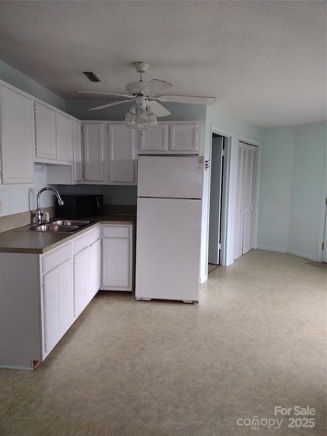 500 Steel Bridge Loop, Hickory, NC 28601 - kitchen featuring freestanding refrigerator, dark countertops, ceiling fan, white cabinetry, and a textured ceiling