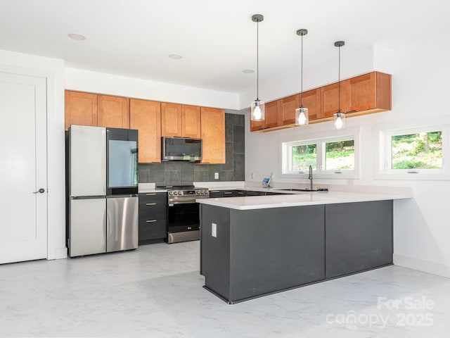 6548 Emerald Isle Dr, Sherrills Ford, NC 28673 - kitchen featuring appliances with stainless steel finishes, a peninsula, tasteful backsplash, pendant lighting, and light countertops
