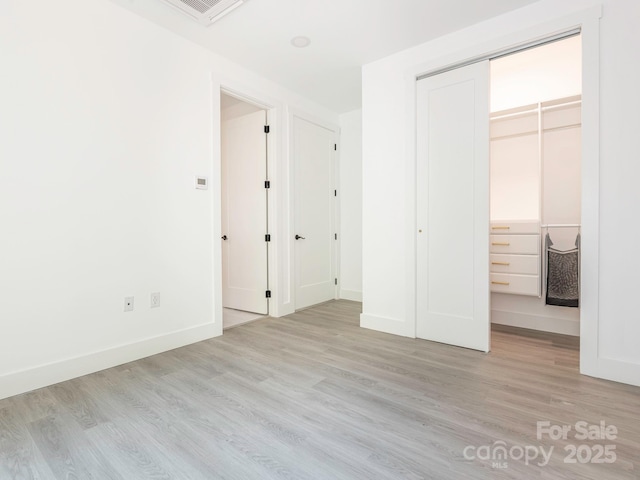 6548 Emerald Isle Dr, Sherrills Ford, NC 28673 - unfurnished bedroom featuring light wood finished floors, a closet, and a walk in closet