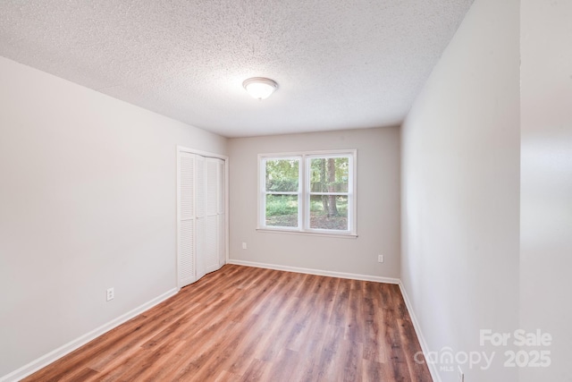 6513 Old Post Rd, Charlotte, NC 28212 - unfurnished bedroom with wood finished floors, a closet, and a textured ceiling