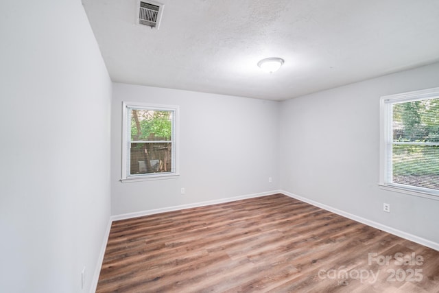 6513 Old Post Rd, Charlotte, NC 28212 - empty room featuring plenty of natural light, wood finished floors, and a textured ceiling
