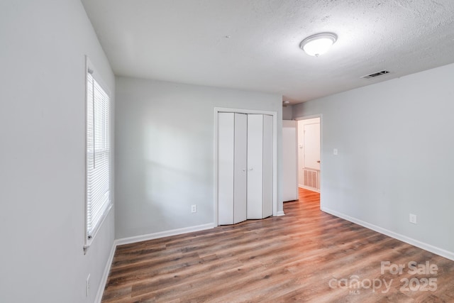 6513 Old Post Rd, Charlotte, NC 28212 - unfurnished bedroom with wood finished floors, a closet, and a textured ceiling