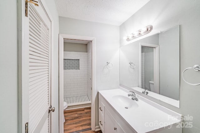 6513 Old Post Rd, Charlotte, NC 28212 - bathroom with a stall shower, vanity, a textured ceiling, a closet, and wood finished floors