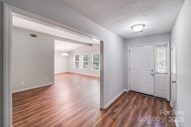 6513 Old Post Rd, Charlotte, NC 28212 - foyer entrance with dark wood-type flooring, a chandelier, and a textured ceiling