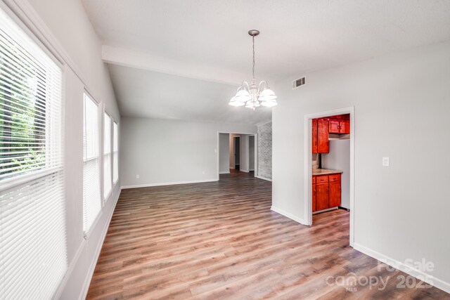 6513 Old Post Rd, Charlotte, NC 28212 - unfurnished dining area with a chandelier, wood finished floors, and vaulted ceiling