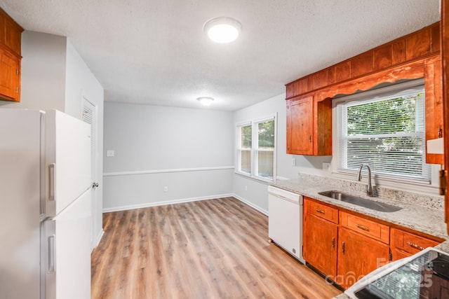 6513 Old Post Rd, Charlotte, NC 28212 - kitchen featuring white appliances, light wood finished floors, a textured ceiling, brown cabinets, and light stone counters