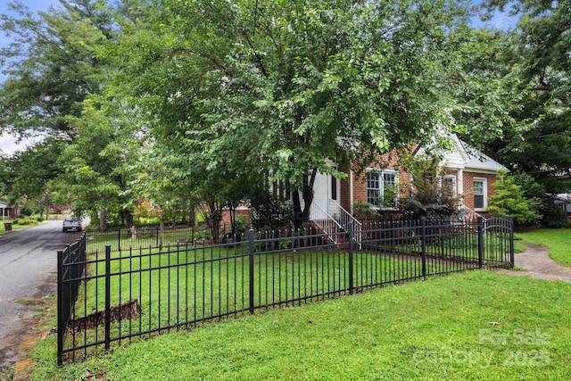 728 Blanton St, Shelby, NC 28150 - view of property hidden behind natural elements with a fenced front yard, entry steps, and brick siding