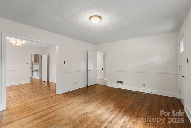 728 Blanton St, Shelby, NC 28150 - empty room with light wood-style flooring, a textured ceiling, and a chandelier