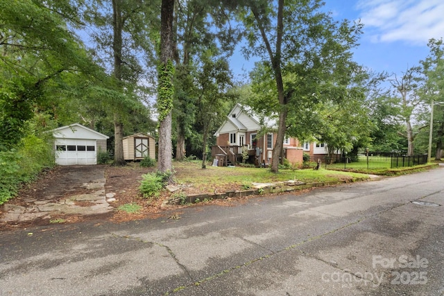 728 Blanton St, Shelby, NC 28150 - view of front of house with a storage unit, a detached garage, driveway, and view of scattered trees