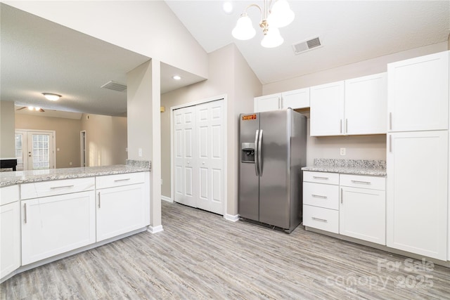11531 Delores Ferguson Ln, Charlotte, NC 28277 - kitchen featuring stainless steel fridge, white cabinetry, light wood finished floors, a chandelier, and vaulted ceiling