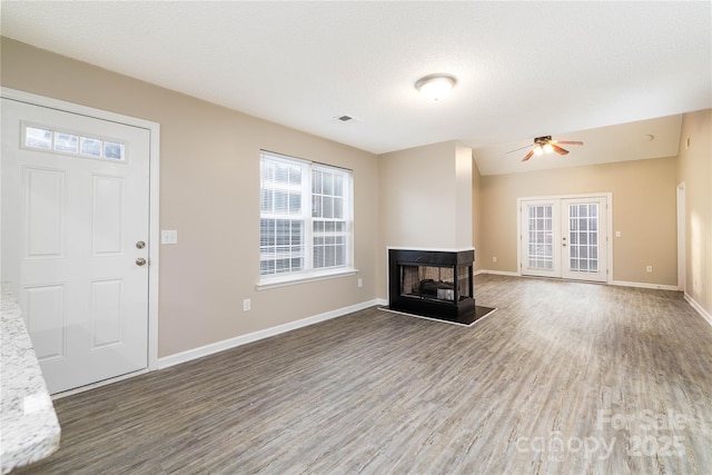 11531 Delores Ferguson Ln, Charlotte, NC 28277 - unfurnished living room featuring wood finished floors, a multi sided fireplace, and a ceiling fan