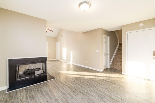 11531 Delores Ferguson Ln, Charlotte, NC 28277 - unfurnished living room with stairway, wood finished floors, ceiling fan, lofted ceiling, and a multi sided fireplace