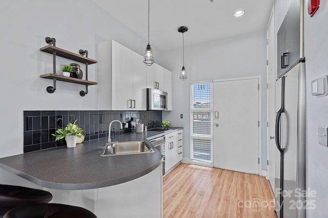 514 W 10th St Unit 302, Charlotte, NC 28202 - kitchen with dark countertops, freestanding refrigerator, dishwasher, light wood-style flooring, and decorative backsplash
