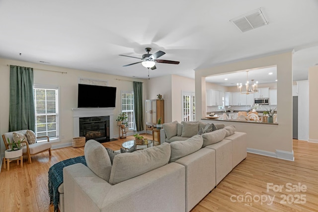 1807 Robbins Meadows Dr, Waxhaw, NC 28173 - living room featuring ceiling fan, a fireplace with flush hearth, light wood finished floors, a chandelier, and recessed lighting