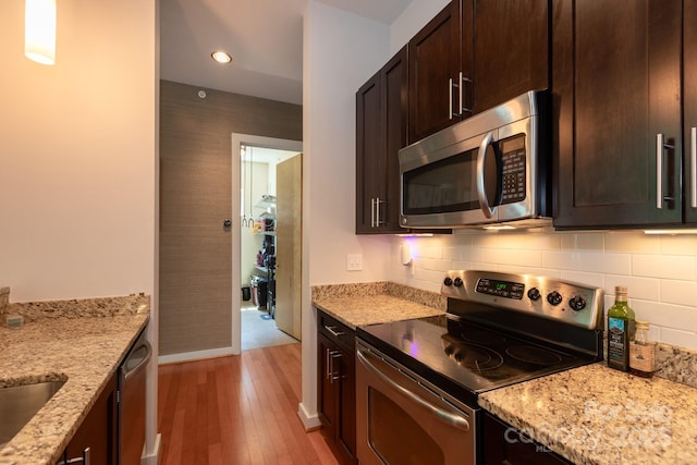 2116 Mcclintock Rd Unit 122, Charlotte, NC 28205 - kitchen with stainless steel appliances, light wood-style floors, dark brown cabinetry, light stone counters, and recessed lighting