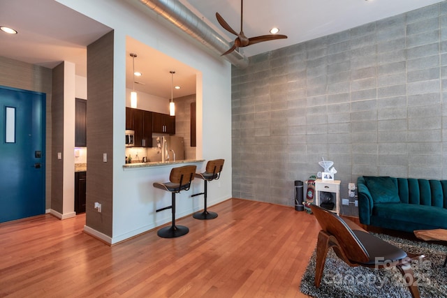 2116 Mcclintock Rd Unit 122, Charlotte, NC 28205 - living room featuring tile walls, a ceiling fan, an accent wall, light wood-style flooring, and recessed lighting