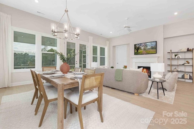 1074 Wylie Falls Ln, York, SC 29745 - dining space featuring a warm lit fireplace, light wood-style flooring, recessed lighting, a chandelier, and ceiling fan