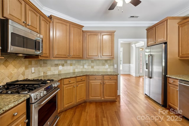 2411 Stoney Run Dr Unit 13, Oakboro, NC 28129 - kitchen with appliances with stainless steel finishes, ceiling fan, light wood-style floors, light stone counters, and crown molding