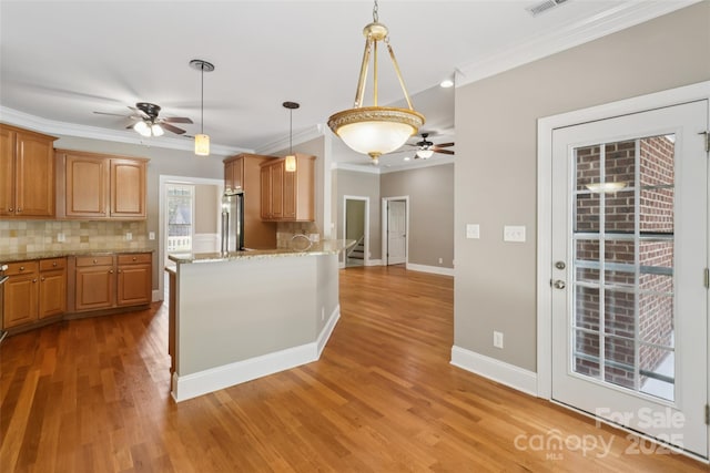 2411 Stoney Run Dr Unit 13, Oakboro, NC 28129 - kitchen featuring ceiling fan, stainless steel fridge, crown molding, decorative backsplash, and light wood-style flooring